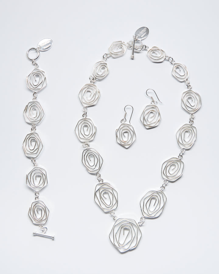 Labyrinth sterling silver necklace, bracelet and dangle earrings by Renata Rubio 92.5 – handcrafted, intricate coiled wire design with a polished finish.