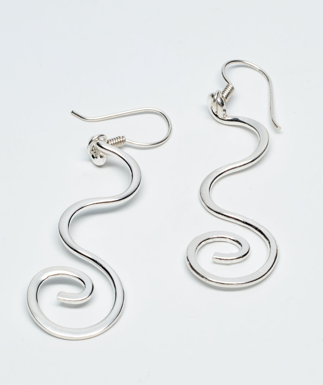 Curled sterling silver dangle earrings with a high-polish finish by Renata Rubio 92.5