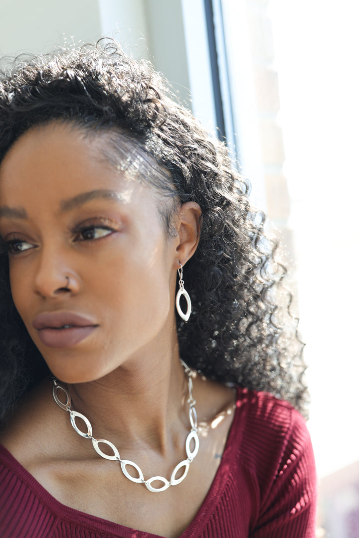 Seed-Shaped Silver Dangle Earrings on Model