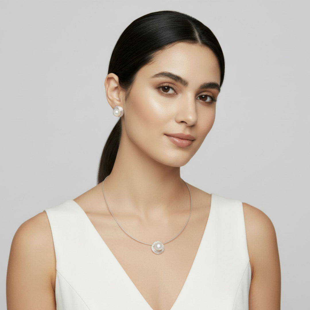 Woman wearing a pearl necklace and Sterling Silver Nest Button Pearl Earrings and Pendant, handmade elegantly designed artisan jewelry.  Renata Rubio 92.5 Handmade fine sterling silver jewelry with a lifetime warranty. 