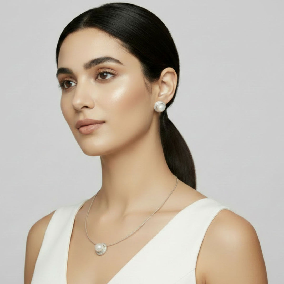 Woman wearing a pearl necklace and Sterling Silver Nest Button Pearl Earrings and Pendant, handmade elegantly designed artisan jewelry.  Renata Rubio 92.5 Handmade fine sterling silver jewelry with a lifetime warranty. 